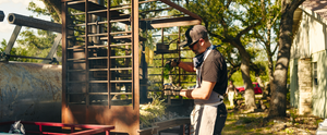 A chef prepares a meal on a beautifully crafted live-fire table, showcasing the artistry of Cen-Tex Smokers.