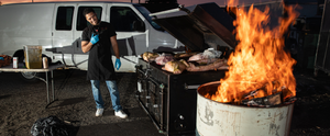 A Cen-Tex Low Country cooker in action, filled with pork and fueled by a traditional fire barrel.