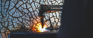 Close-up of a skilled welder using a torch to carefully craft a custom smoker.